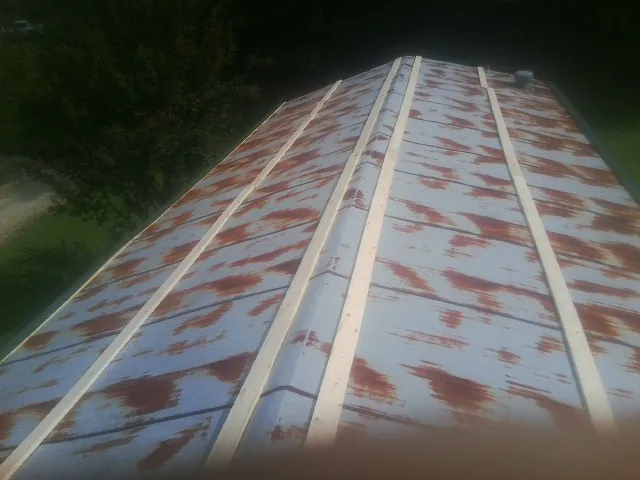 Rusted metal roof panels with new wood purlins before replacement — Storm Damage Roof Repair in Kenedy by Roofing Brothers