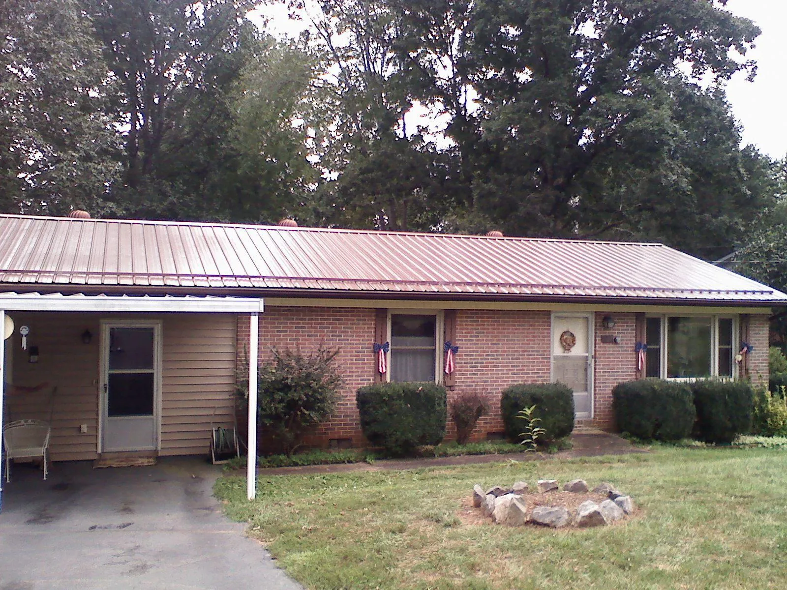 Bronze metal roof and carport on a brick ranch home — Roof Repair work by our crew in Kenedy