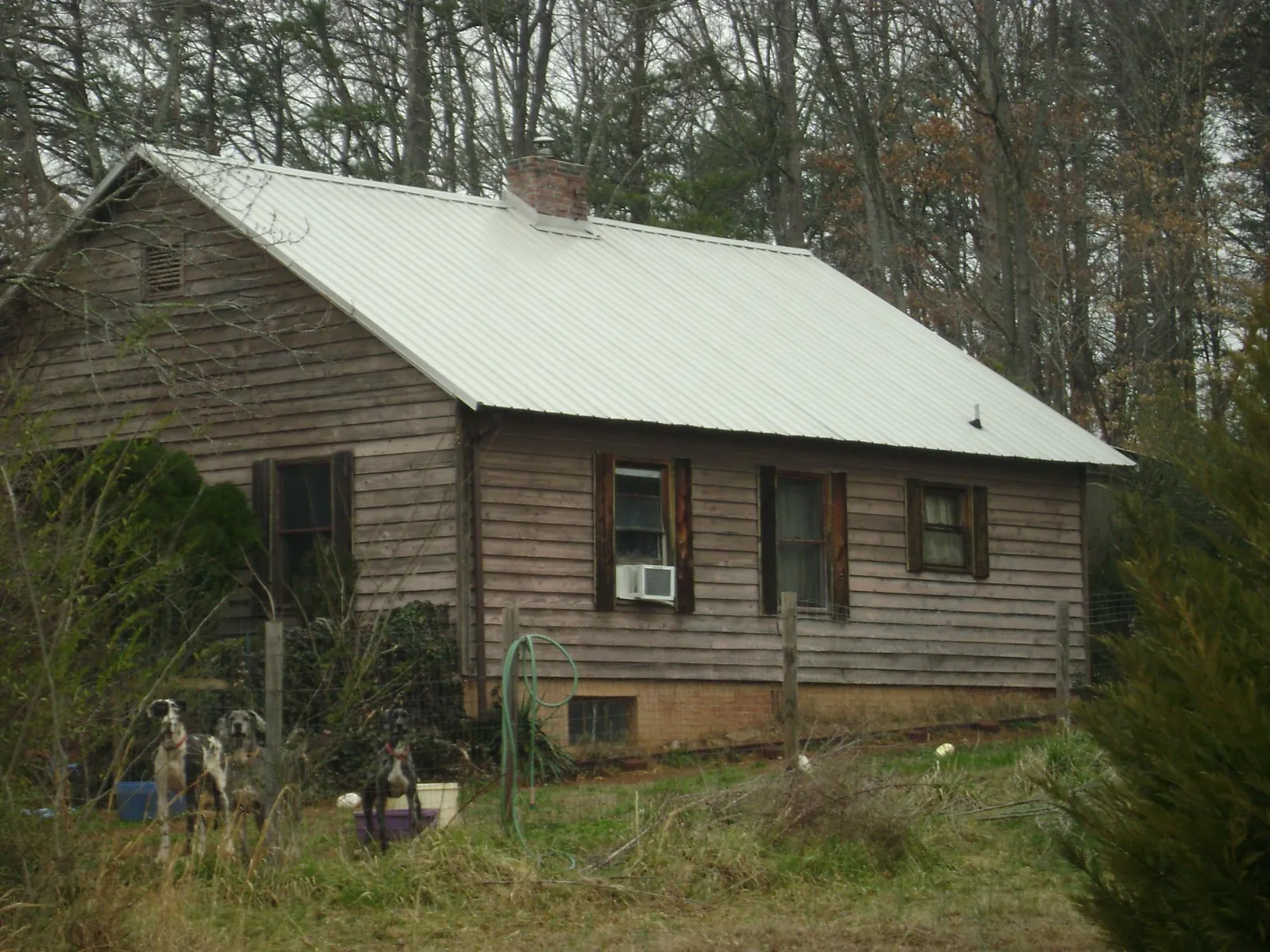 White metal roof on an old wood sided farmhouse, from a Metal Roof Installation job in Kenedy